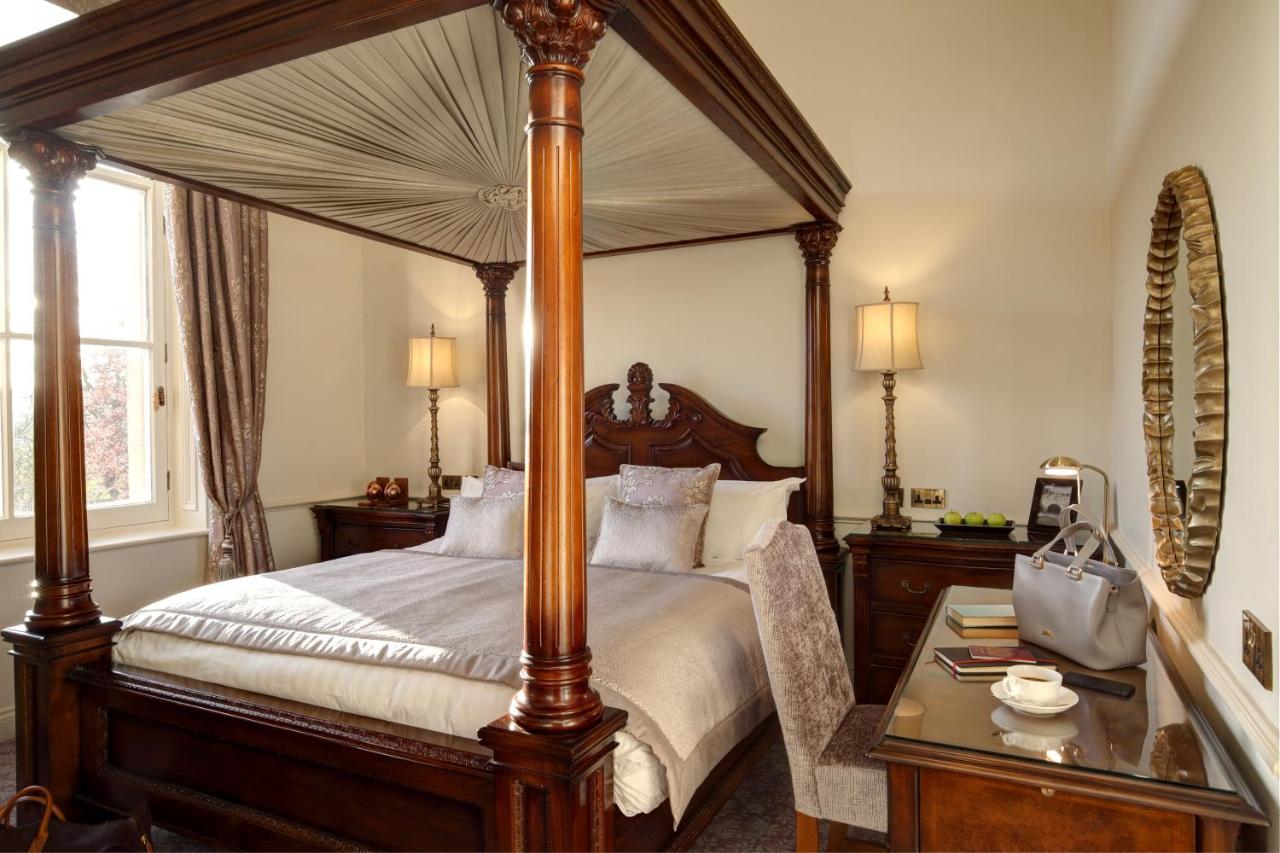 a bedroom with a large canopy bed and a table at Macdonald Bath Spa Hotel in Bath