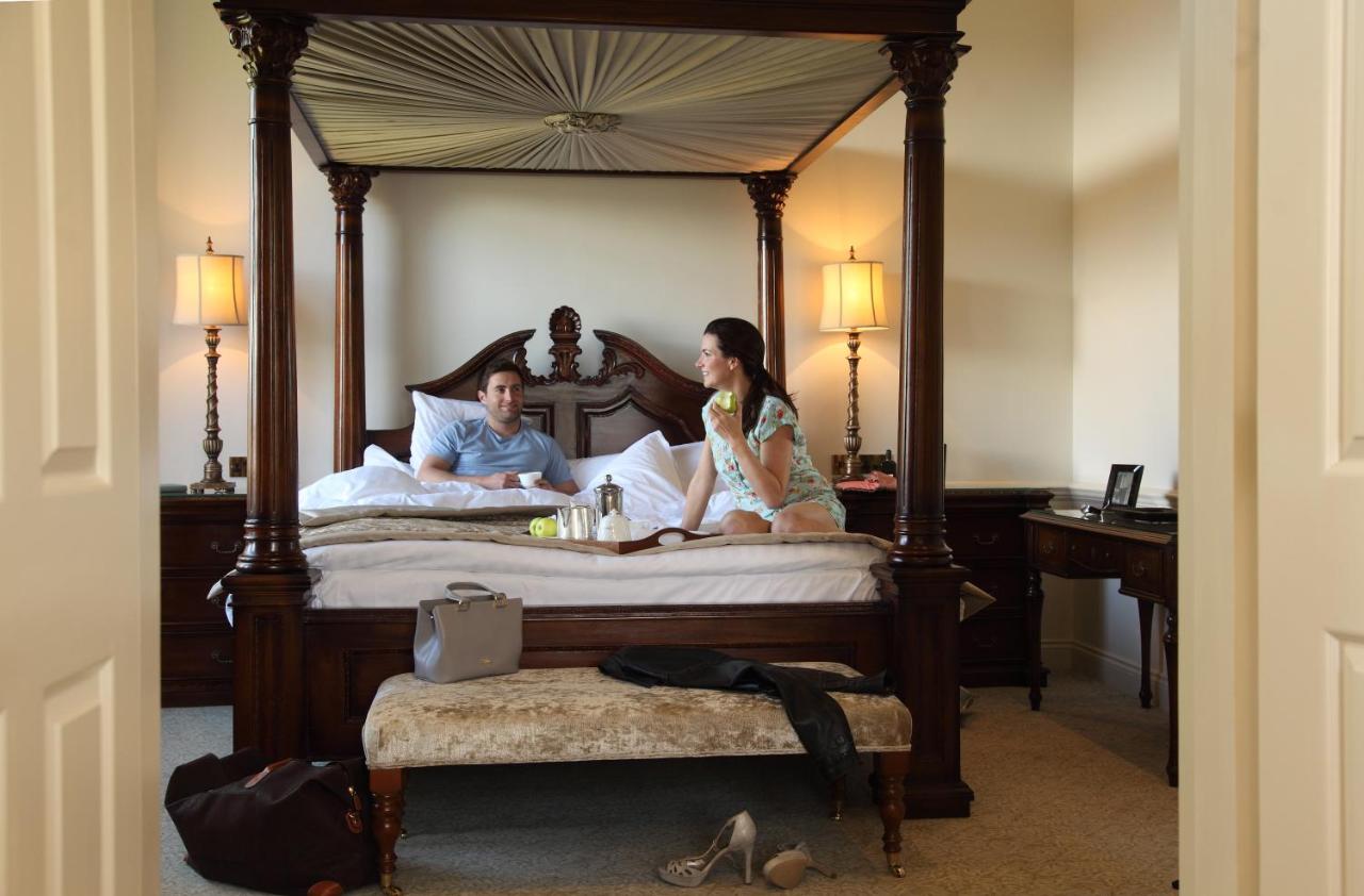 a man and a woman sitting on a bed at Macdonald Bath Spa Hotel in Bath